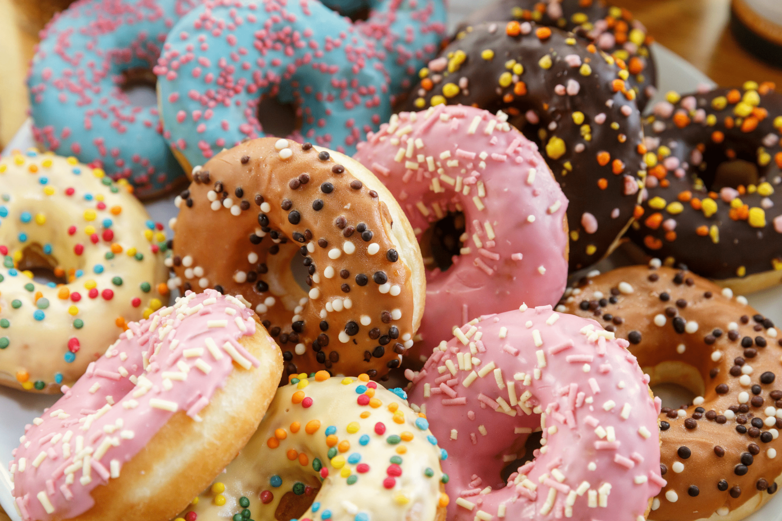 A stack of glazed donuts covered in sprinkles