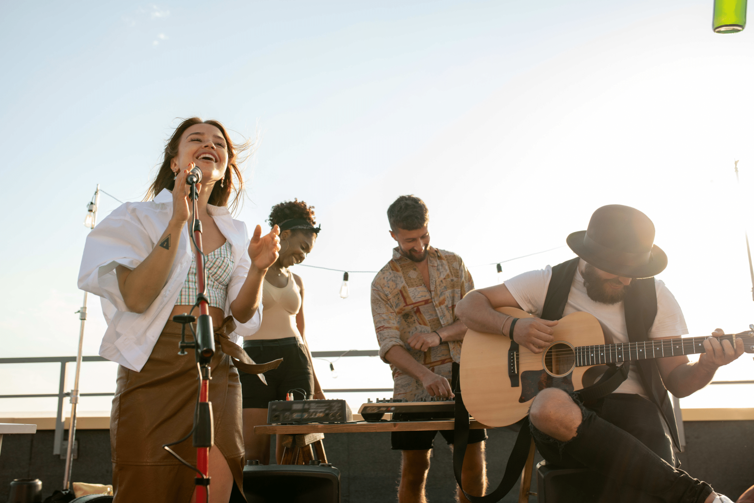 girl singing with a guy playing acoustic guitar next to her on a stage with two people behind them