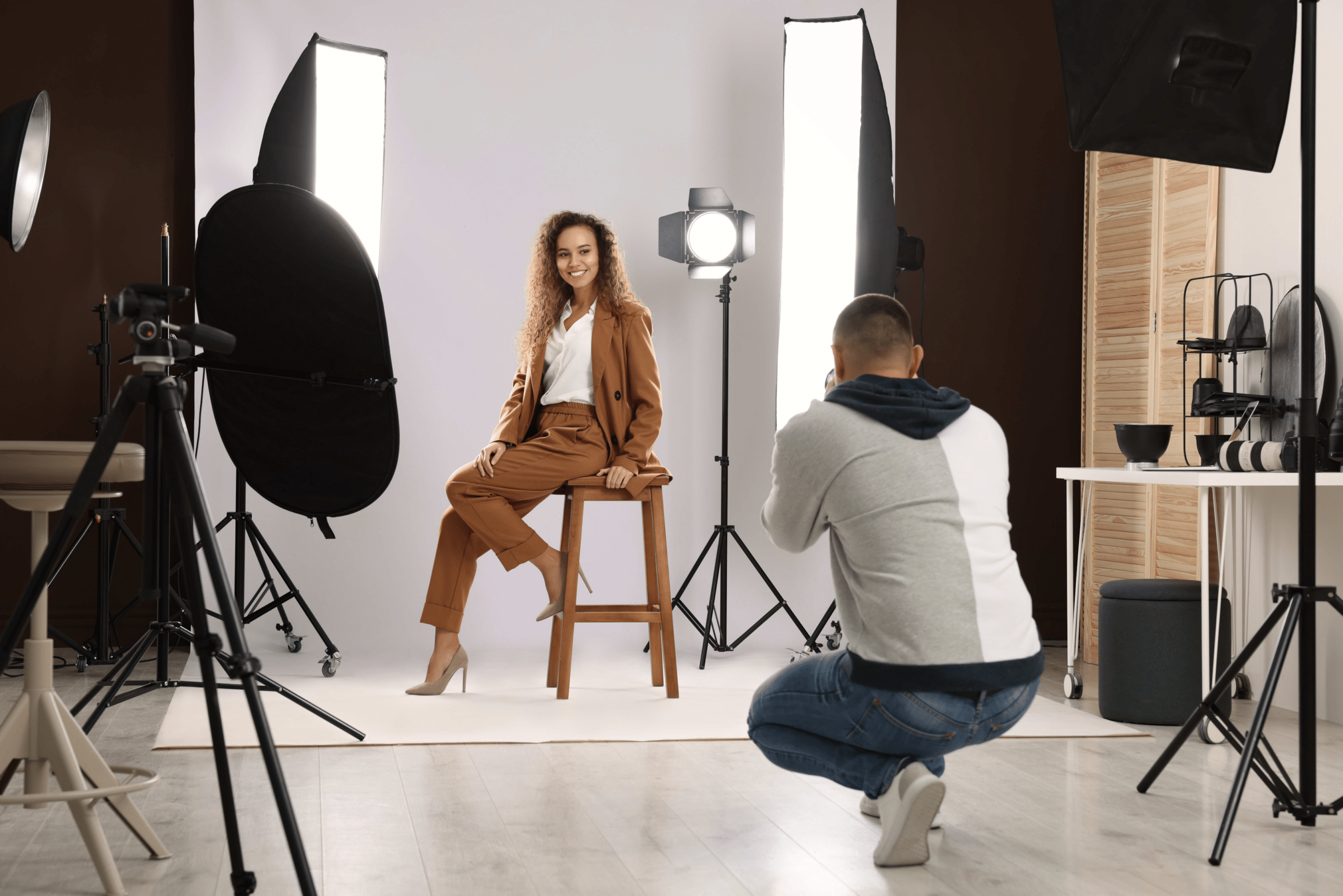 A college student in a business suit getting professional headshots taken with a photographer