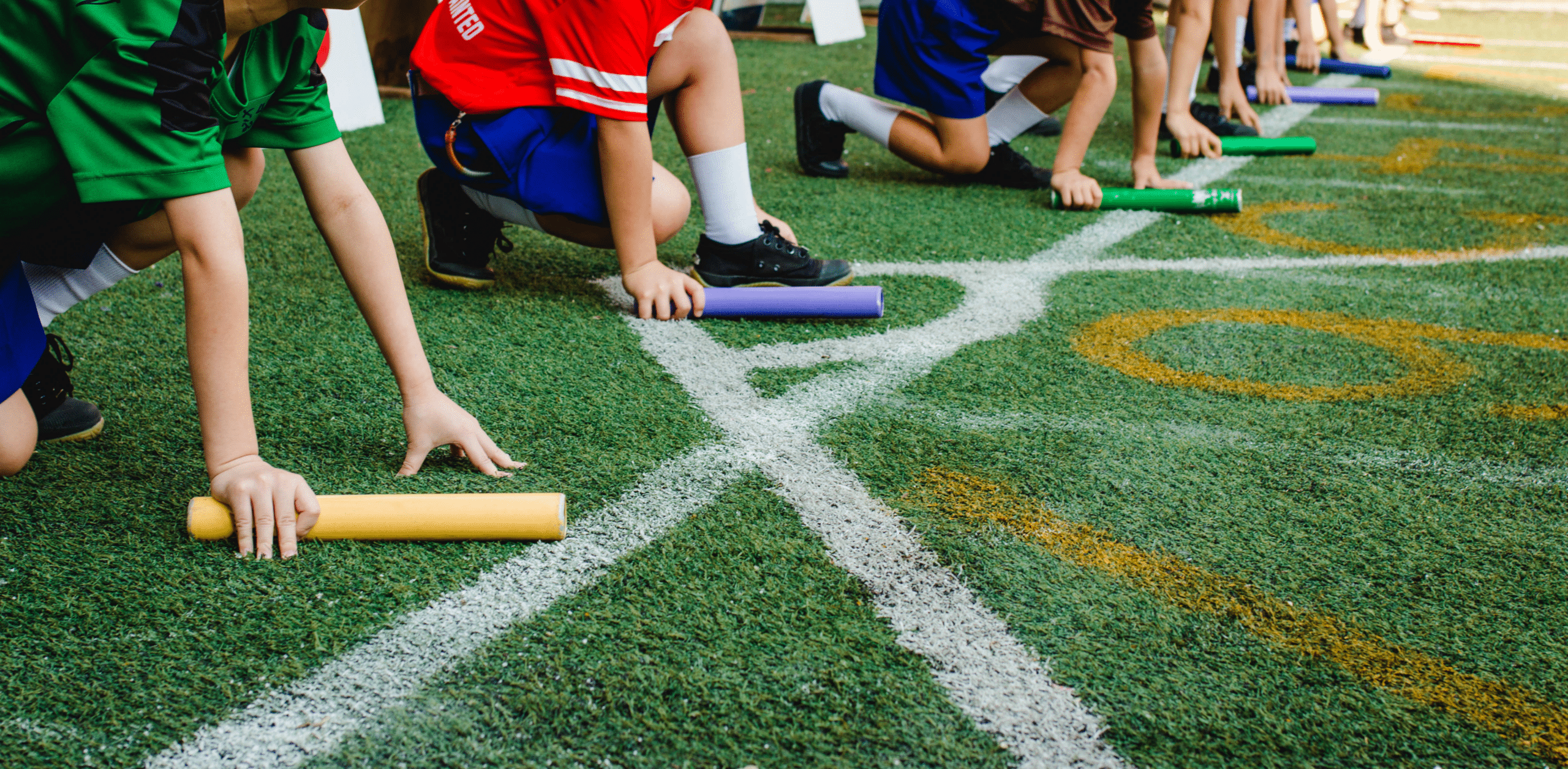 kids lined up with a baton about to start a relay race