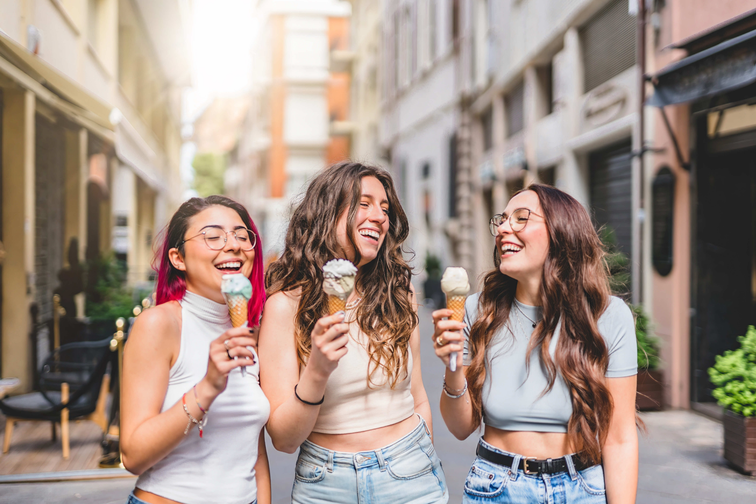 group of three girls laughing and eating ice cream