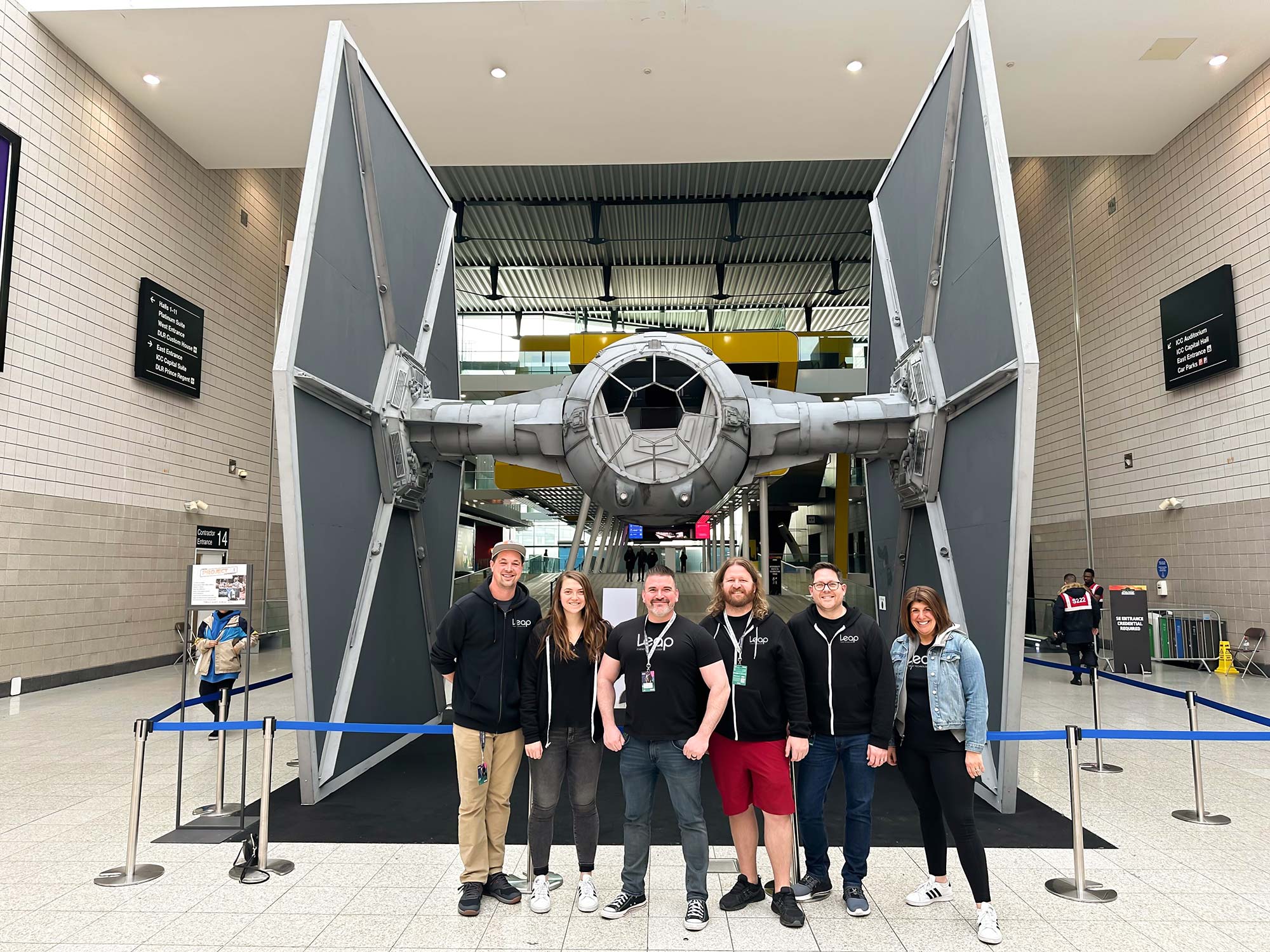 A group of Leap employees in front of a TIE fighter at a Star Wars event