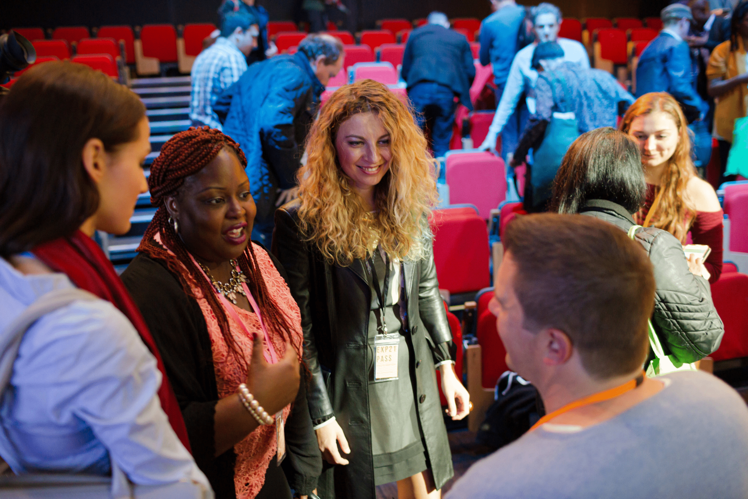 diverse group of young people with badges on talking at a conference