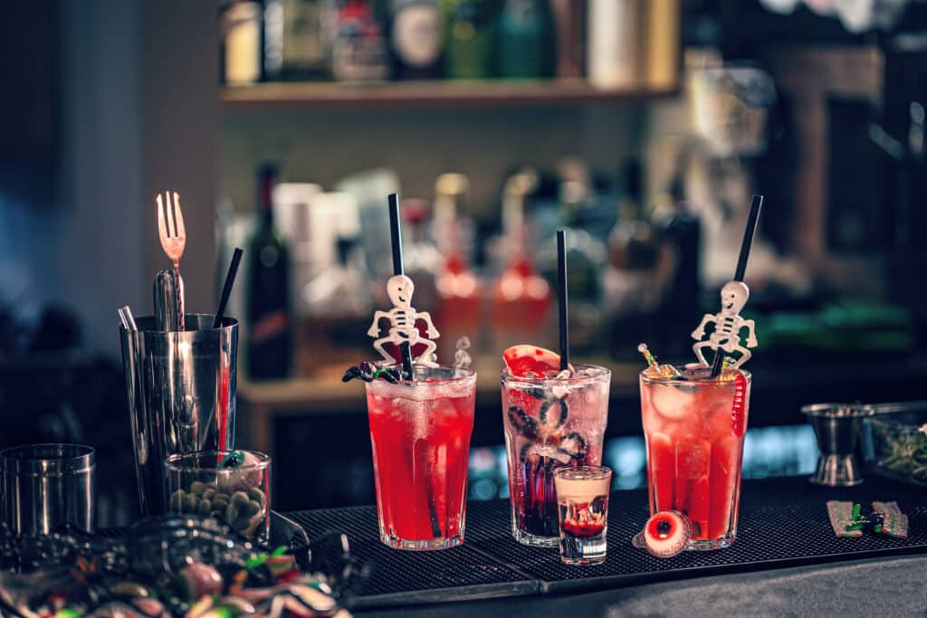 Halloween cocktails with halloween decor on bar counter