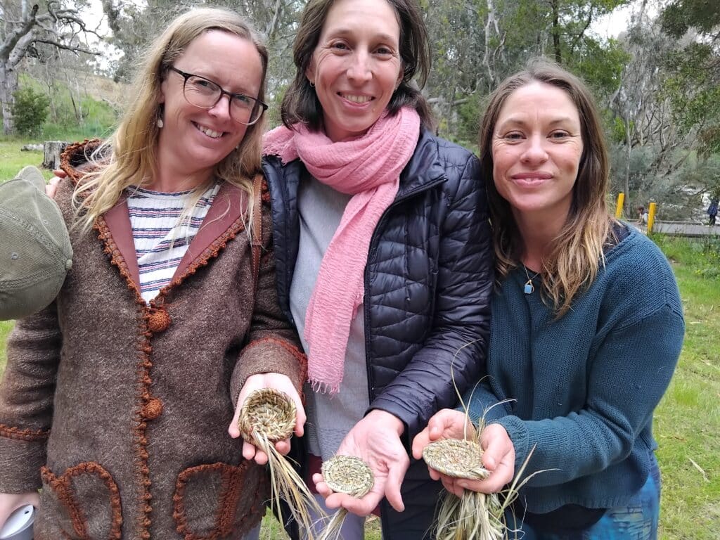 three women holding woven baskets and smiling