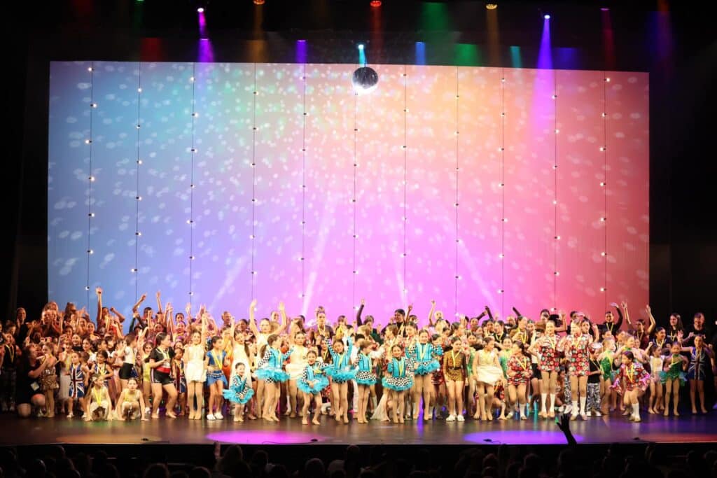 stage with disco ball and tons of dancers of all ages