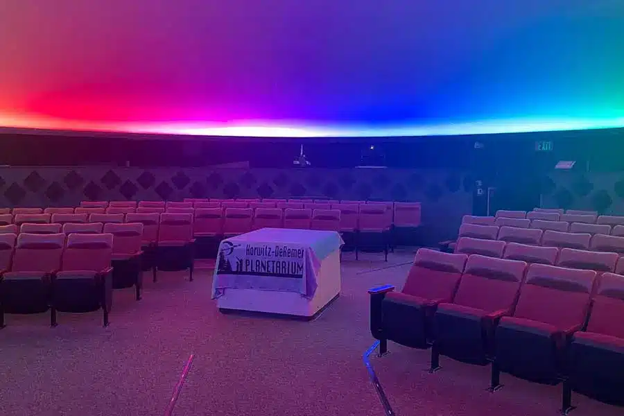 Horwitz-DeRemer Planetarium neon lights in ceiling with viewing seats and branded table in the aisle