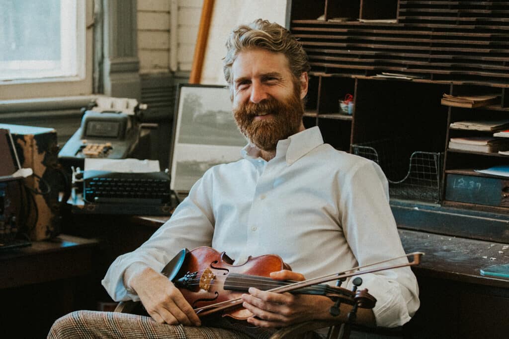 sean dietrich posing with a fiddle